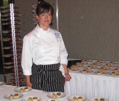 A photo of a female chef with plates of food