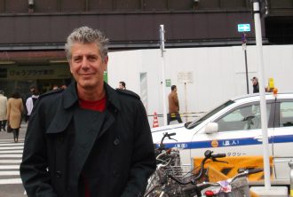 A photo of a man on a street smiling.