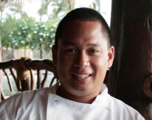 A photo of a smiling chef in a white chef coat